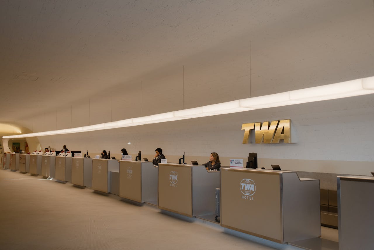 our-journey-02 Reception desks at TWA Hotel, showcasing retro-modern design in JFK Airport, New York.